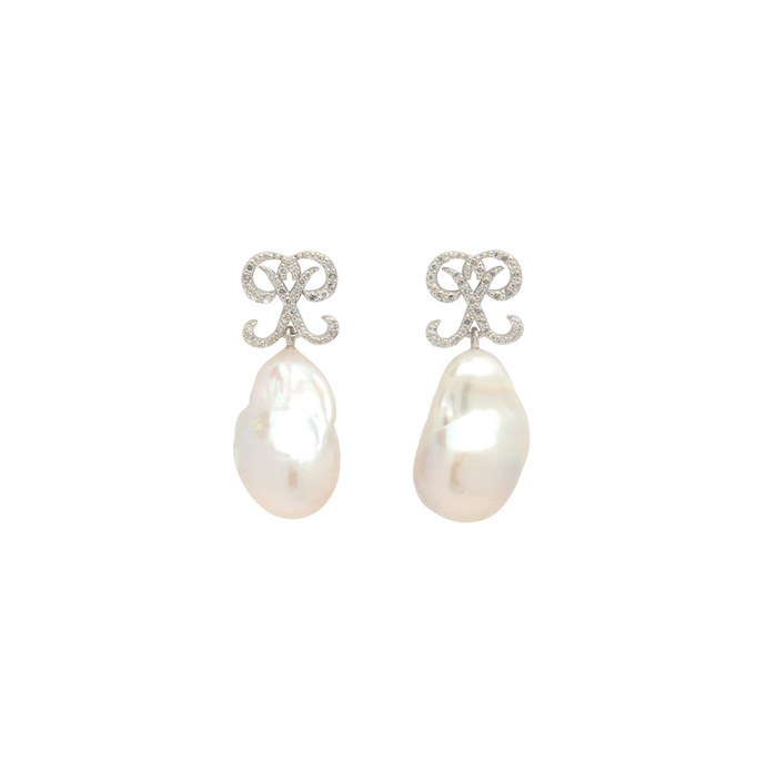 PANTOLIN MONOGRAM PEARL EARRINGS SILVER Pantolins monogram med vackra barockpärlor där monogrammet är dekorerat med vita safirer. Varje pärla är unik så storleken skiljer sig från par till par.